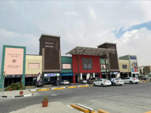 Aswaaq shopping center exterior storefronts and outdoor parking, KhaleejFusion