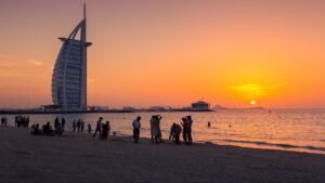 Graphic banner displaying the title 'Best Time to Visit Dubai Beaches' over a tropical turquoise sea scene, KhaleejFusion
