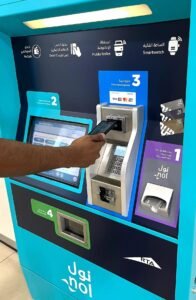 A commuter paying contactless via smartphone at an RTA Nol card top-up machine, KhaleejFusion