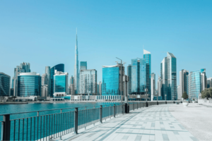 Scenic view of the Dubai waterfront promenade with modern skyscrapers and the Burj Khalifa under a clear blue sky, Khaleej Fusion