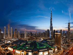 Aerial evening view of Downtown Dubai showcasing the illuminated Burj Khalifa, surrounding skyscrapers, and Dubai Mall at night, Khaleej Fusion
