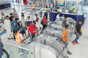 Commuters queuing and passing through automated entry turnstiles at a Dubai transport station. Khaleej Fusion
