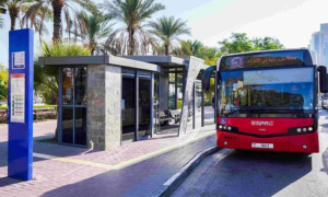 Modern RTA public bus stopped at a shaded bus shelter station in Dubai, Khaleej Fusion