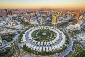 Aerial view of Jumeirah Village Circle showcasing its distinctive circular townhouse clusters and surrounding Dubai urban landscape, Khaleej Fusion
