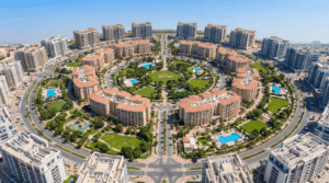 Aerial view of Jumeirah Village Circle featuring the central park and circular residential architecture in Dubai, Khaleej Fusion